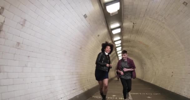 Millennial friends running through tunnel — Stock video