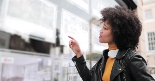 Young adult african american looking at estate agents window — Video