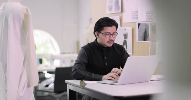 Modedesignerin arbeitet mit Laptop an Muster — Stockvideo