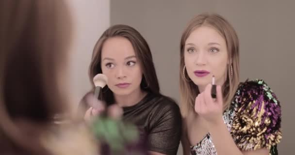 Vackra unga vuxna kvinnor gör make up i badrumsspegeln — Stockvideo