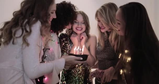Kvinna blåser ut ljus på födelsedagstårta på fest — Stockvideo