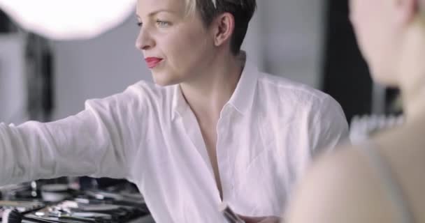 Make-up umělec pracující na modelu na focení — Stock video
