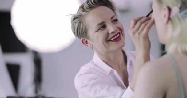 Make-up kunstenaar werken aan een model op een fotoshoot — Stockvideo