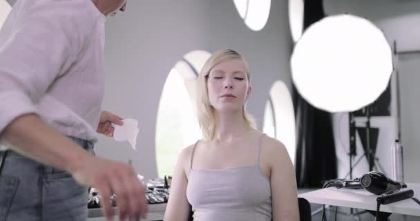 Trucco artista facendo modelli eyeliner su un servizio fotografico Video Stock