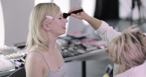 Makeup καλλιτέχνης που εργάζονται σε ένα μοντέλο σε μια φωτογράφηση — Αρχείο Βίντεο