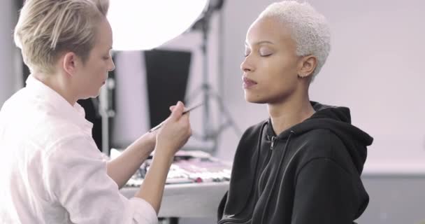 Make-up umělec pracující na modelu na focení — Stock video