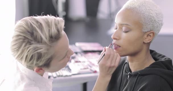 Makeup artist arbetar på en modell på en fotografering — Stockvideo