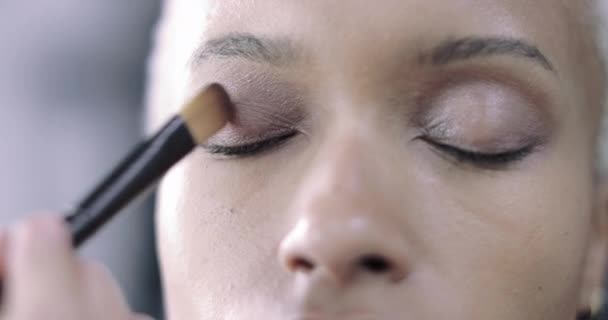 Cierre de la sombra de los ojos aplicado por un artista de maquillaje. — Vídeos de Stock
