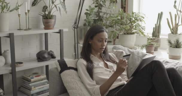 Latin Kvinna på soffan köpa online med kreditkort på ipad — Stockvideo