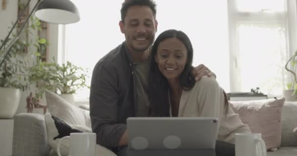 利用数码平板电脑在沙发上拥抱的情侣 — 图库视频影像