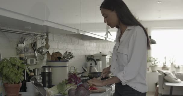 Evde yemek yapan yetişkin bir kadın dijital tabletten yemek tarifine bakıyor. — Stok video