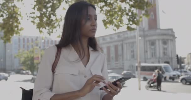 Ενηλίκων Latin θηλυκό στο δρόμο ψάχνει για έξυπνο τηλέφωνο περιμένει για ταξί — Αρχείο Βίντεο