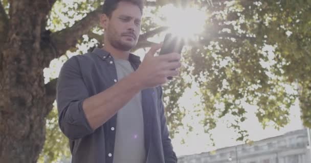 Erwachsener Mann schaut auf der Straße auf Smartphone und wartet auf Taxi — Stockvideo