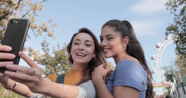 Φιλενάδες Πάρτε μια Selfie κατά τη διάρκεια των καλοκαιρινών διακοπών με τροχό Ferris στο παρασκήνιο — Αρχείο Βίντεο