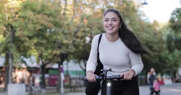 Női ingázó elektromos robogó a nyilvános parkban — Stock videók