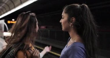 Metro istasyonunda tren bekleyen kız arkadaşlar.