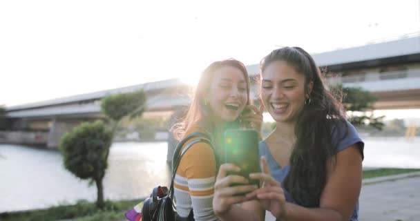 Dziewczyny Zrób sobie selfie na nabrzeżu o zachodzie słońca w lecie — Wideo stockowe