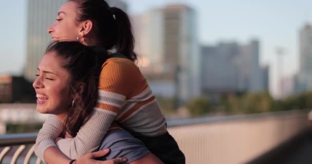 Şehirde kız arkadaşını omuzlarında taşıyan bir kadın. — Stok video