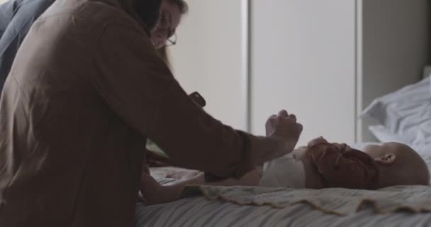 Vader verschoont luiers van baby in slaapkamer — Stockvideo