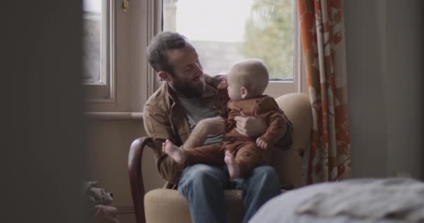 Padres solteros que juegan con un niño en silla en el dormitorio — Vídeos de Stock