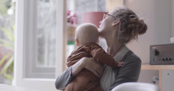 Alleenstaande moeder praat liefdevol met baby jongen in de woonkamer — Stockvideo