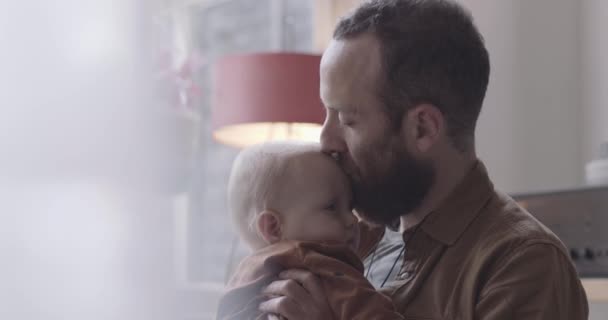 Samotny ojciec całuje małego chłopca w czoło i obejmuje — Wideo stockowe