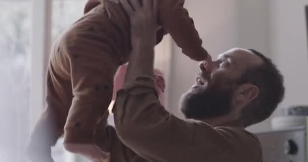 Único pai levanta bebê menino no ar brincalhão — Vídeo de Stock