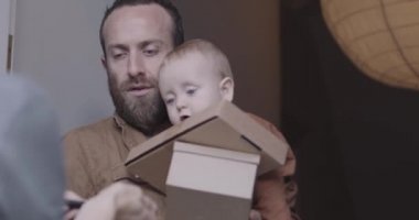Yetişkin erkek baba ön kapıda paket alıp imzalıyor.