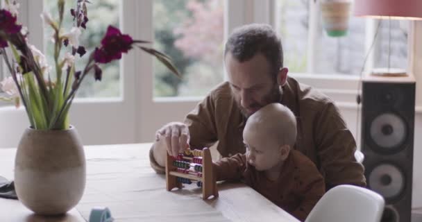 Single Father teaching his baby counting with abacus — Stock Video