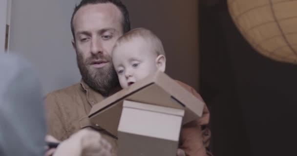 Erwachsener männlicher Vater empfängt und unterschreibt Pakete vor der Haustür — Stockvideo