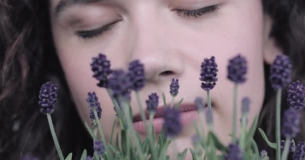 Молода доросла жінка пахне лавандою з закритими очима — стокове відео