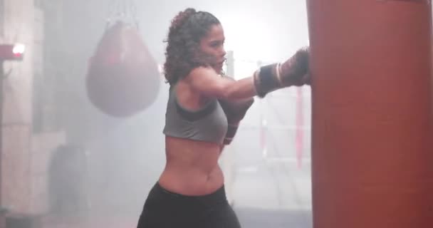 Vrouwelijke training met een bokszak — Stockvideo