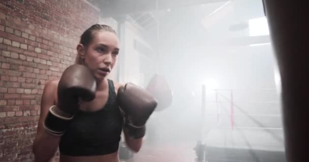 Frauen turnen mit einem Boxsack — Stockvideo