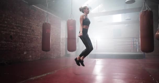 Genç yetişkin kadın boks kulübünde ip atlıyor. — Stok video