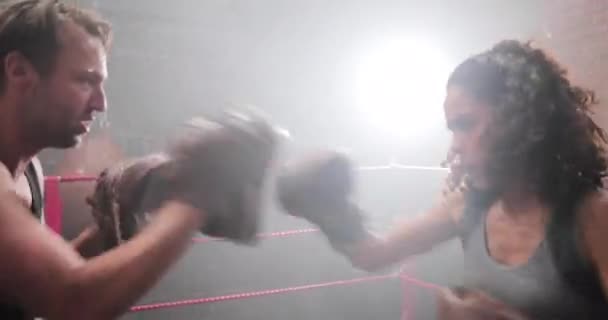 Boxeador femenino con entrenador utilizando almohadillas focalizadas — Vídeo de stock