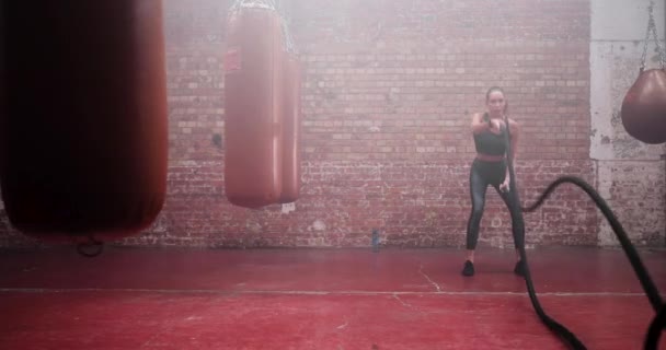 Mladá dospělá žena cvičí s bojovými lany — Stock video