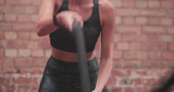 Closeup young adult female working out with battle ropes — Stock Video