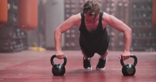 Adult male doing dumbbell pushups at the gym — Stock Video