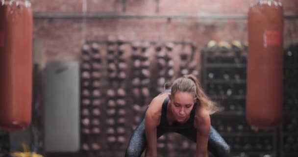 Jonge volwassen vrouw flipping band voor een body building workout — Stockvideo