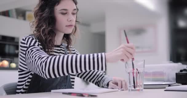 Jonge volwassen vrouw kunstenaar schilderen in studio — Stockvideo