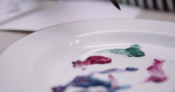 Close-up of paint brush and paint on plate — Stock Video