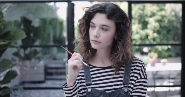 Retrato de la joven pintora adulta en estudio — Vídeos de Stock