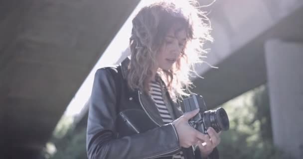 Fotógrafa joven adulta en situación urbana con cámara retro. — Vídeo de stock