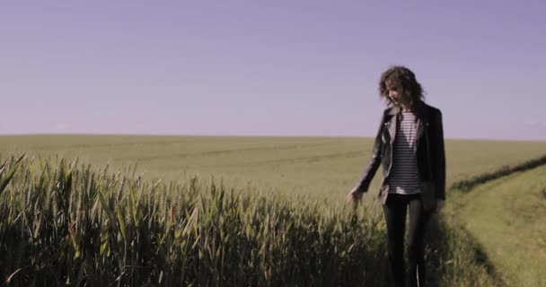 Молодая женщина, бегущая по полям культуры — стоковое видео