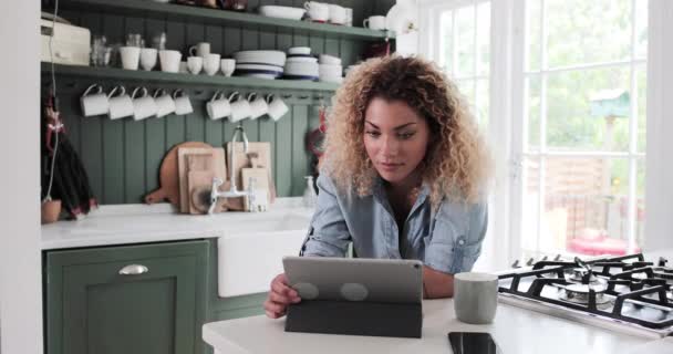 Mujer adulta mirando la tableta digital mientras toma café por la mañana — Vídeos de Stock