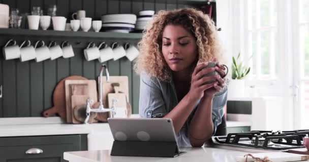 大人の女性はデジタルタブレットを見ながら朝のコーヒーを持っている — ストック動画