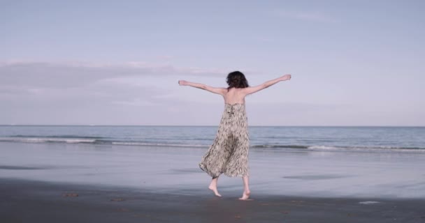 海のそばで踊る若い大人の女性 — ストック動画
