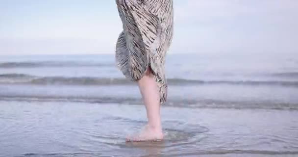 Giovane donna adulta girovagando in abito sulla spiaggia al tramonto — Video Stock