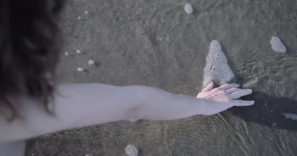 Närbild av kvinna hand leka med vatten i havet — Stockvideo