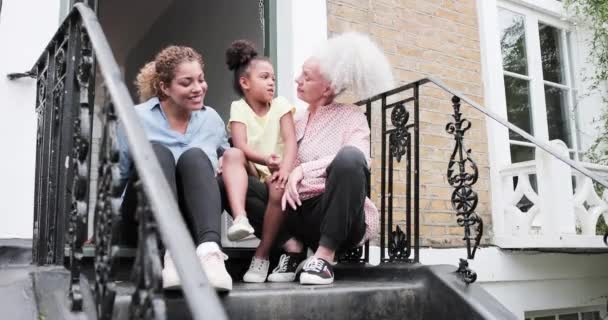 Tres generaciones de mujeres sentadas fuera del hogar familiar — Vídeos de Stock